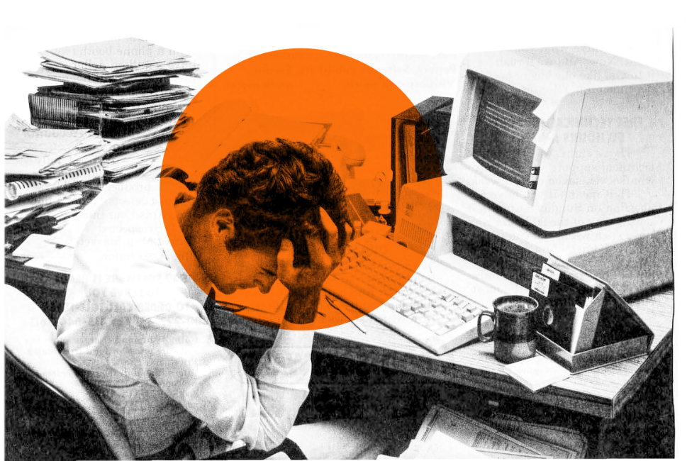 un homme se prend la tête dans le main, assis à son bureau vintage encombré de papiers